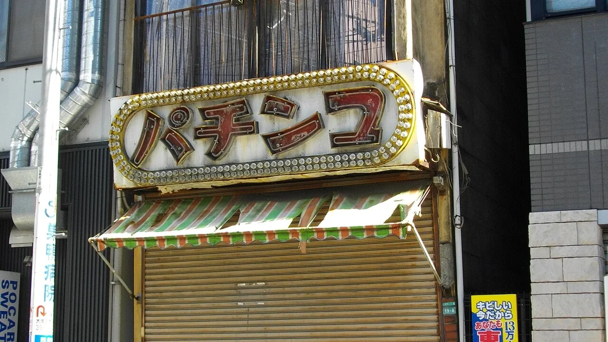 Pachinko parlor exterior entrance displaying official municipal police operating permits